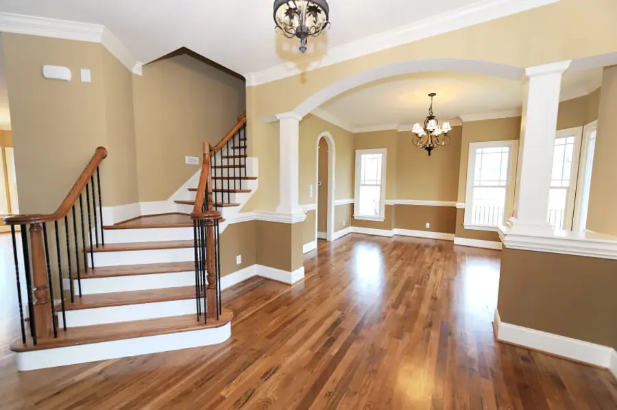 A stair hall and dining room painted in warm neutrals with white trim